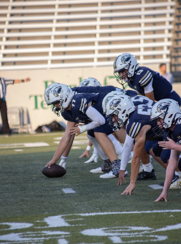 A football offense lines up before the snap on the field.