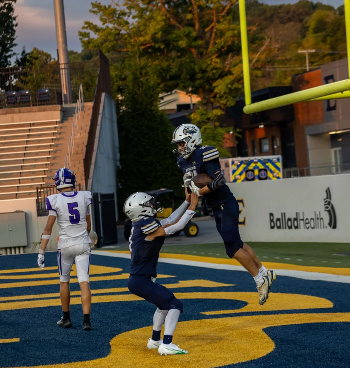 Football teammates celebrate together in the end zone before the game.
