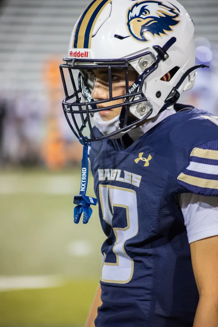 A helmeted football player stands in profile before the game.