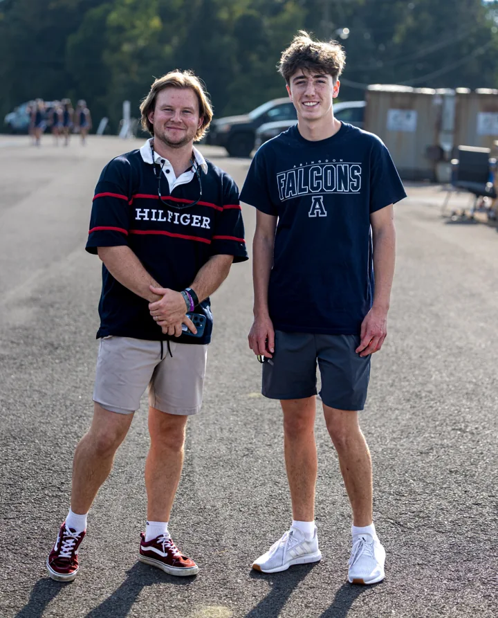 Two people smile together outdoors at a community gathering.