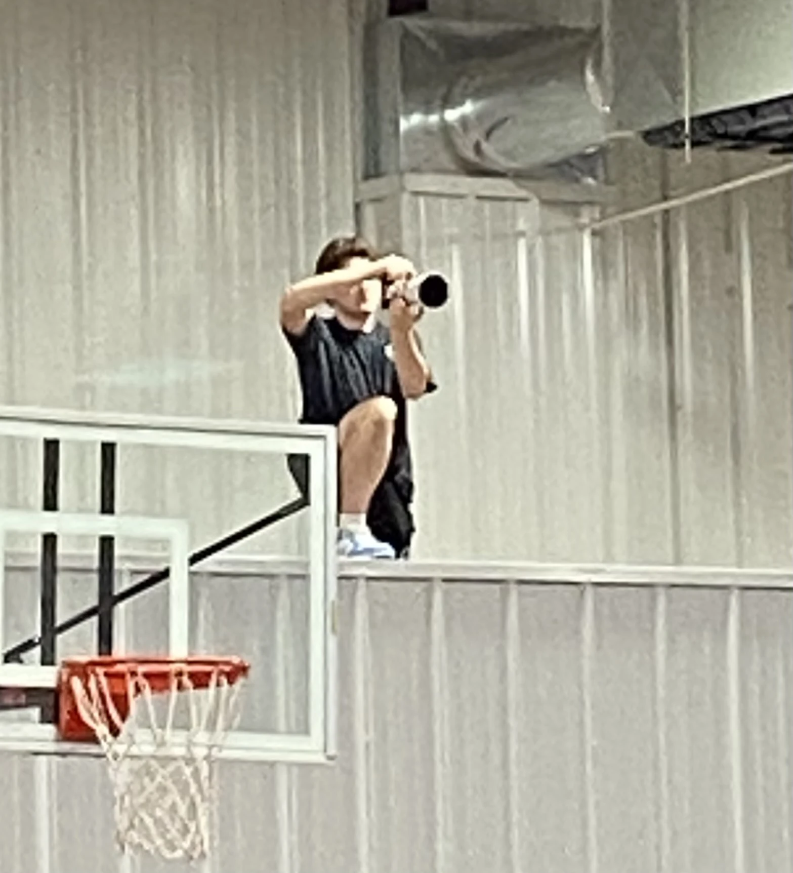 Joseph Lester photographing basketball from above the court with his Canon camera.